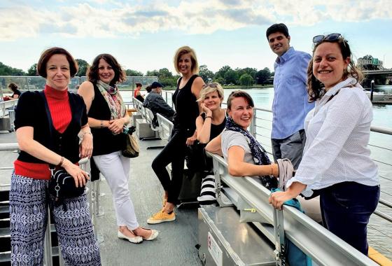 7 staff members from ECNL sitting and standing on a ship deck.