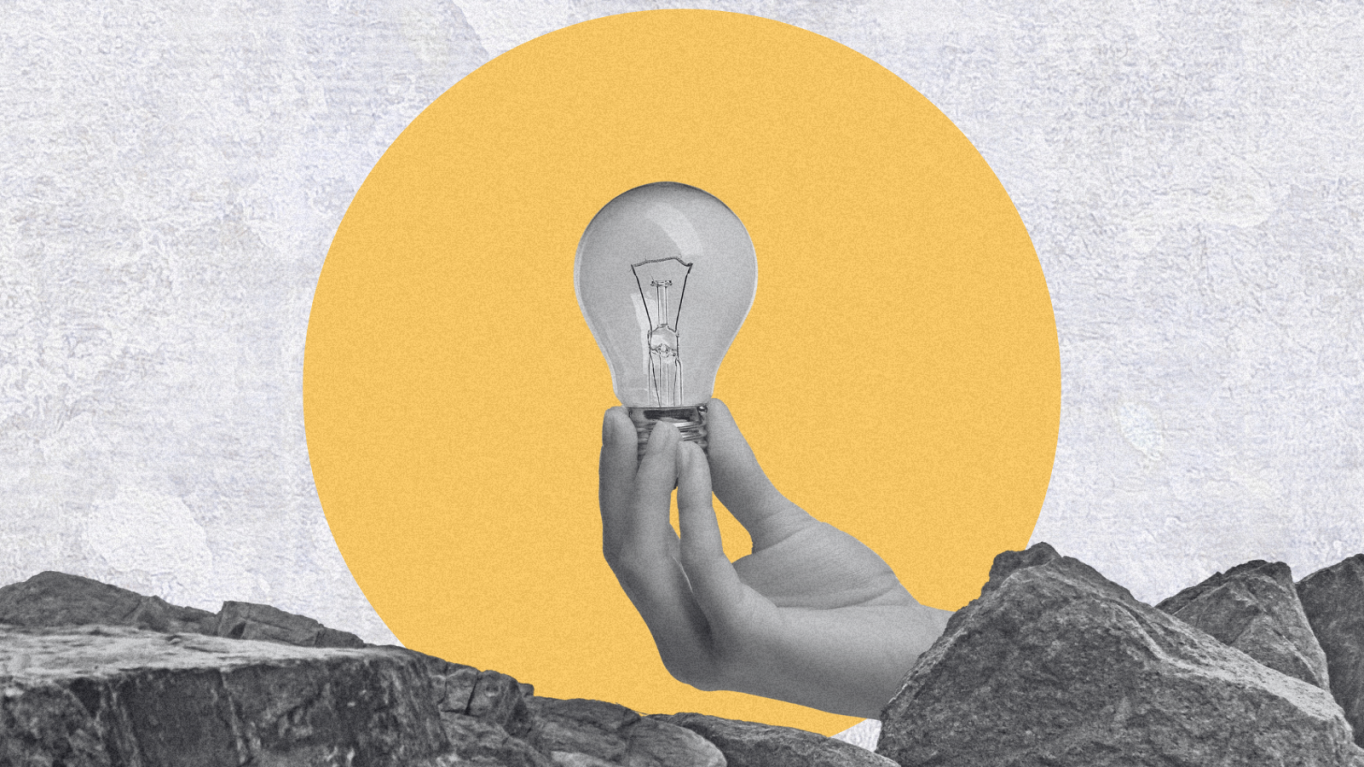 In the background some black and white rocky mountains. in the middle a yellow circle. In the front a black and white hand holding a light bulb.